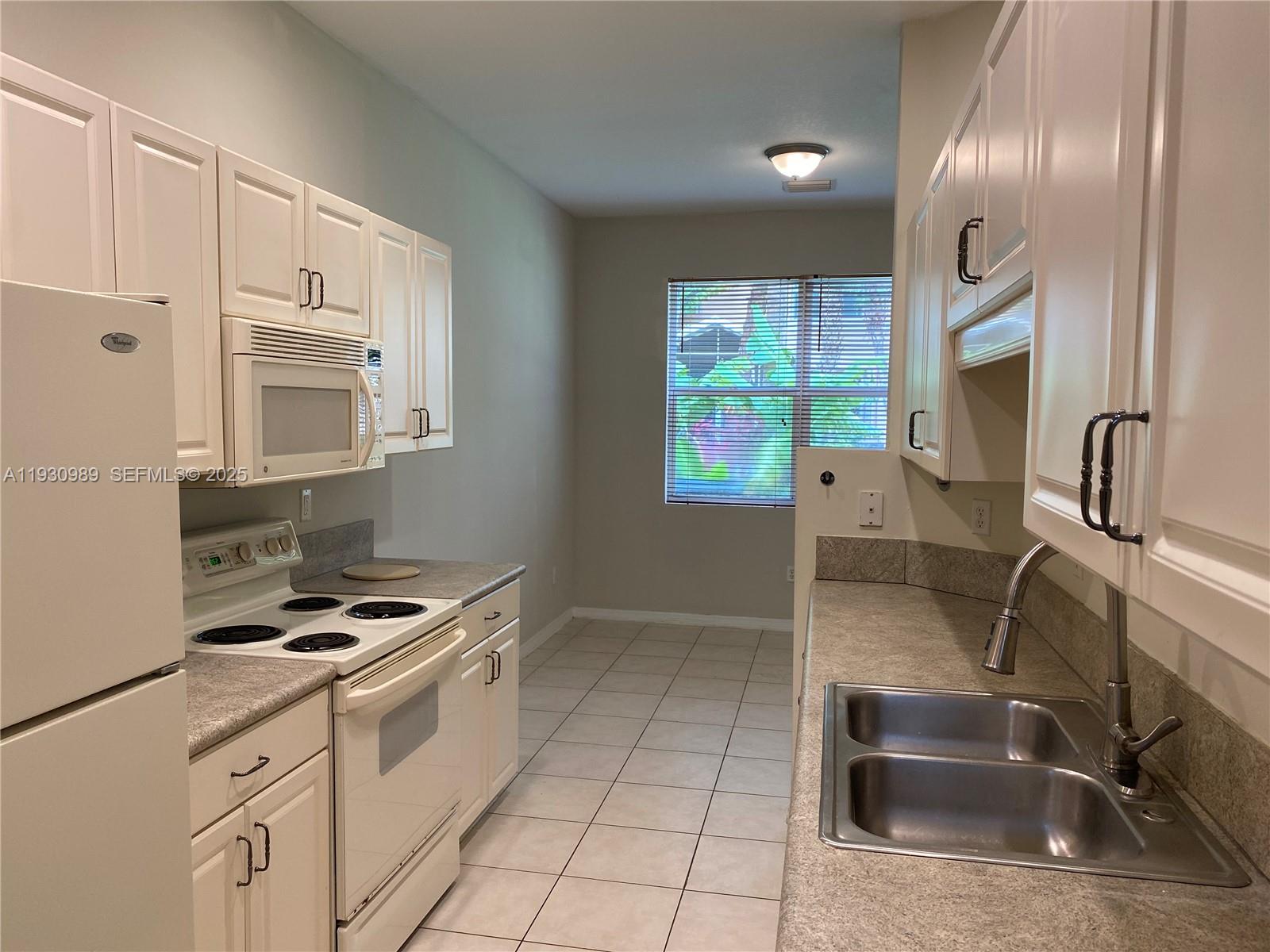 112 Wakulla Springs Way, Unit 112 Royal Palm Beach, FL 33411 - Photo 7 of 20 a kitchen that has a sink cabinets and window