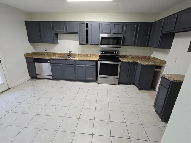a kitchen with stainless steel appliances a stove a sink and a refrigerator