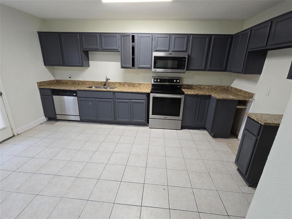 10500 Lake June Road, Unit I03 Dallas, TX 75217 - Photo 3 of 11 a kitchen with stainless steel appliances a stove a sink and a refrigerator