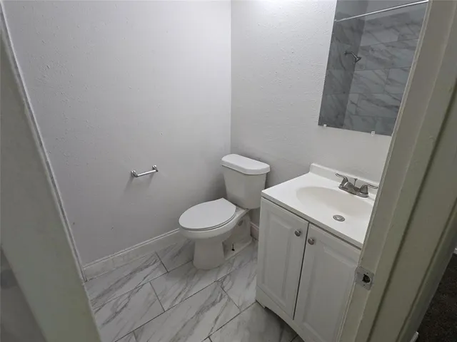 a white toilet sitting next to a white sink