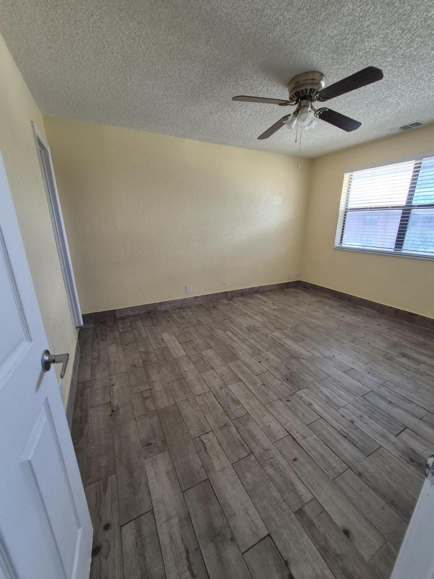 10039 Winding Lake Road, Unit 202 Sunrise, FL 33351 - Photo 12 of 14 wooden floor in an empty room