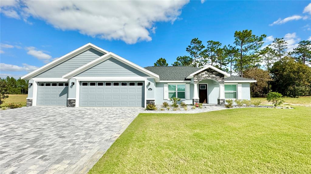 a front view of a house with a garden and trees