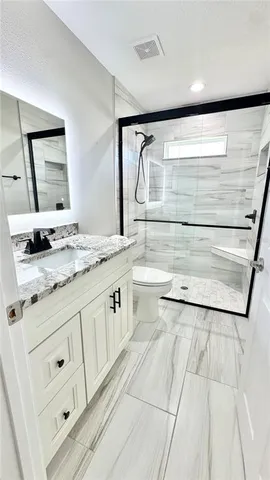 a bathroom with a granite countertop sink and a mirror