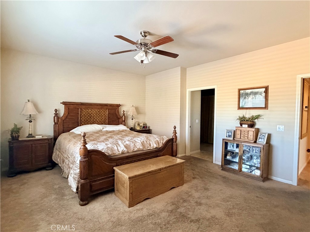 19422 Royal Oaks Road Apple Valley, CA 92308 - Photo 16 of 30 a bedroom with a bed and a chandelier