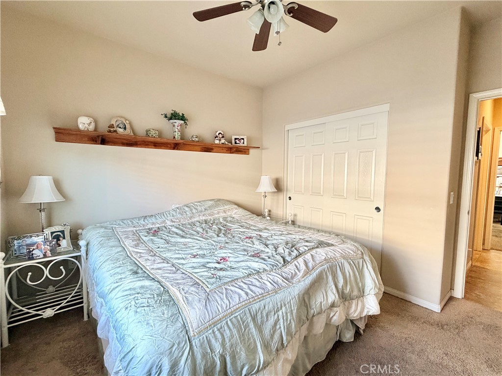 19422 Royal Oaks Road Apple Valley, CA 92308 - Photo 20 of 30 a bedroom with a bed and a chandelier