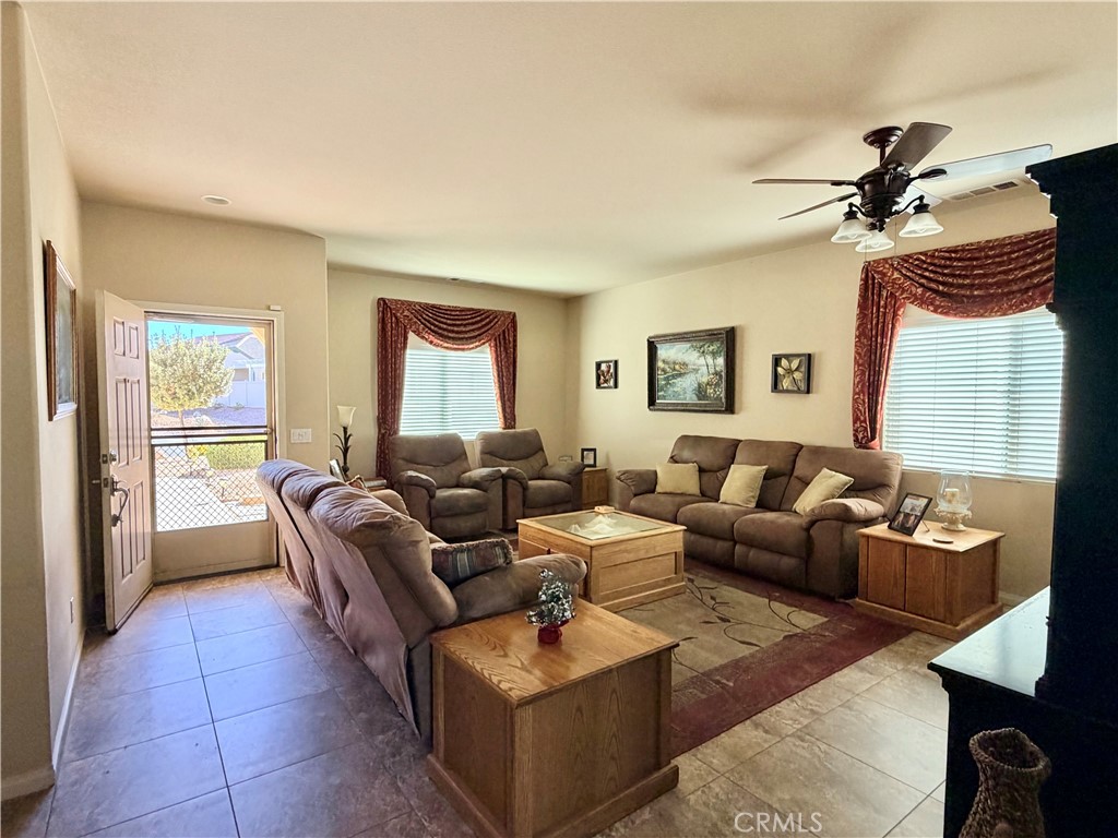 19422 Royal Oaks Road Apple Valley, CA 92308 - Photo 5 of 30 a living room with furniture a large window and a rug