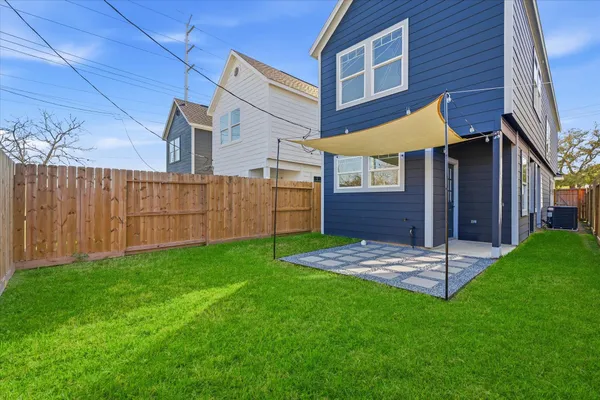 a view of backyard of house with wooden fence
