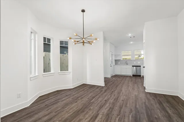 a view of empty room with wooden floor and window