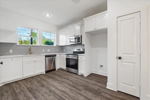 a kitchen with granite countertop white cabinets and white appliances