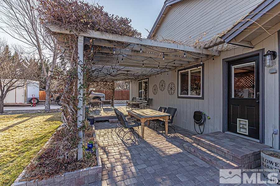 14545 Ghost Rider Drive Reno, NV 89511 - Photo 24 of 24 a view of a patio with table and chairs barbeque oven and a yard