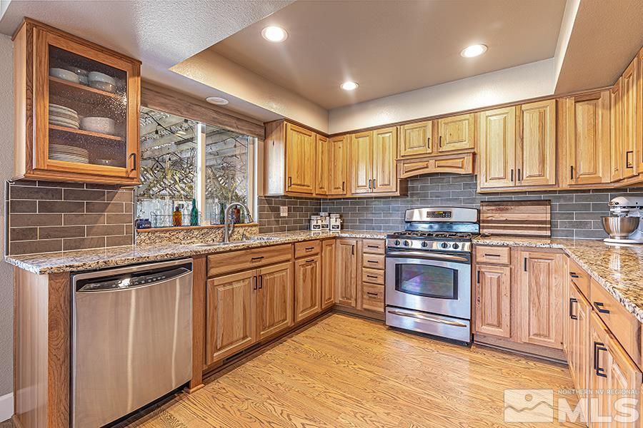 14545 Ghost Rider Drive Reno, NV 89511 - Photo 8 of 24 a kitchen with stainless steel appliances granite countertop a stove sink and cabinets