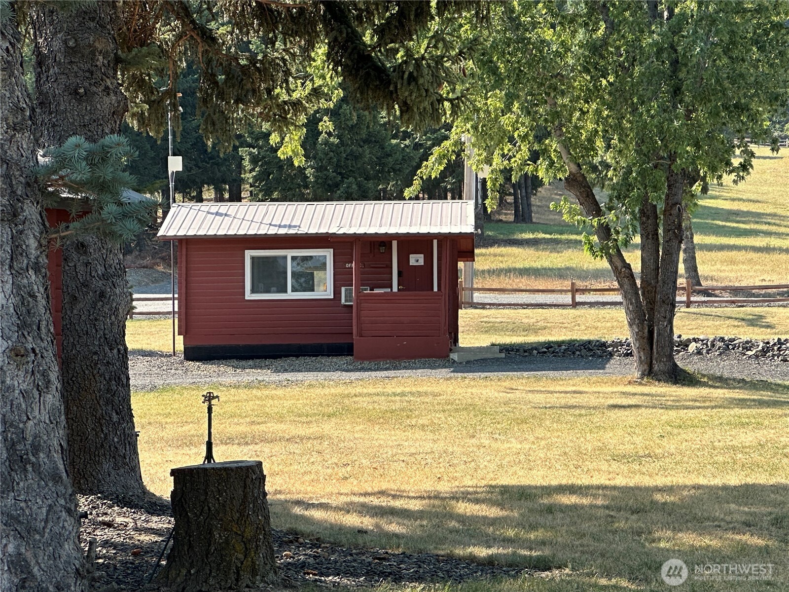 680 Horse Heaven Road Cle Elum, WA 98922 - Photo 9 of 11 a view of a patio with table and chairs with wooden fence and large trees