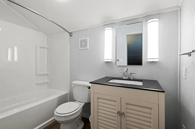 a bathroom with a sink toilet vanity tub and shower