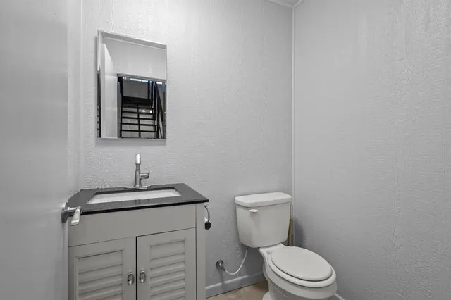 a white toilet sitting next to a bathroom sink