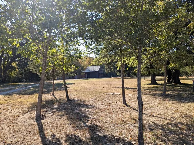 a view of a yard with wooden fence