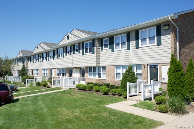1355 Roanoke Avenue, Unit 3 Riverhead, NY 11901 - Photo 1 of 2 a front view of a house with a yard table and chairs