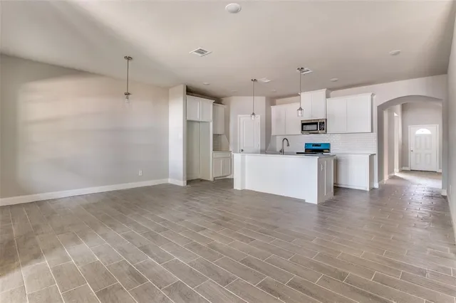 a view of a kitchen with wooden floor and electronic appliances