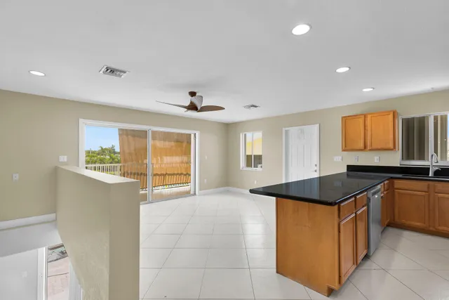 a kitchen with stainless steel appliances granite countertop a sink and a refrigerator