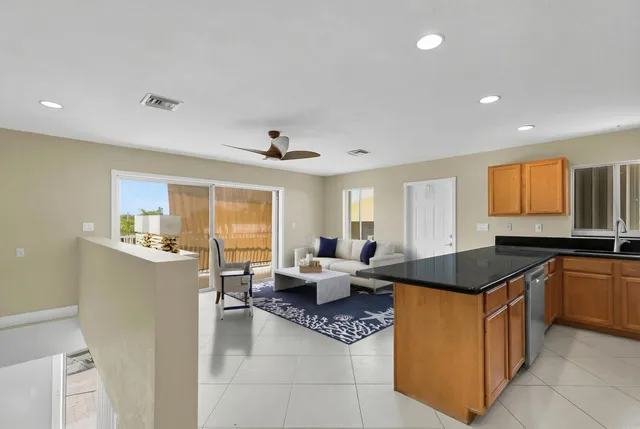 a kitchen with stainless steel appliances granite countertop a sink a refrigerator a stove and a refrigerator with wooden floor