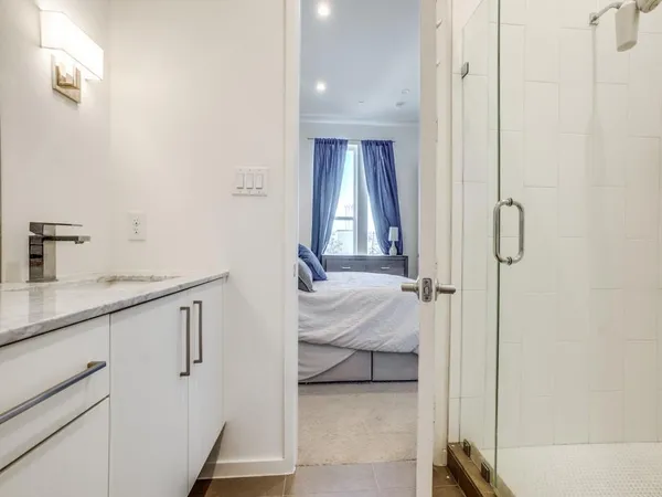 a en suite bathroom with a shower sink and mirror