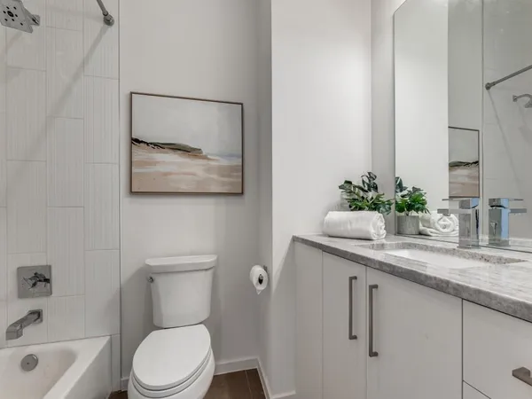 a bathroom with a granite countertop sink a toilet and a bathtub