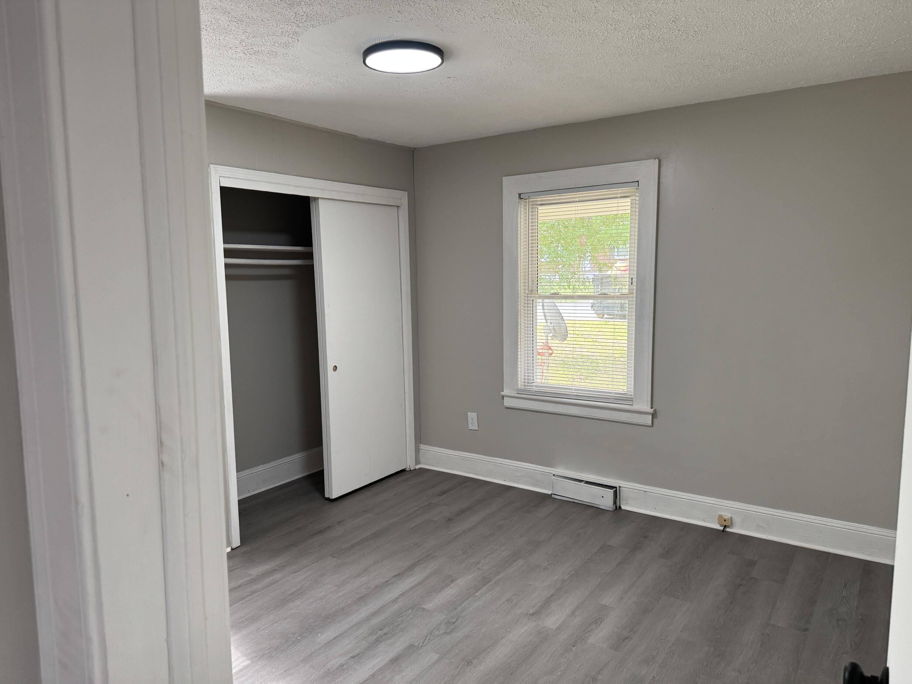 136 Nelson Avenue Danville, VA 24540 - Photo 4 of 7 an empty room with wooden floor and windows