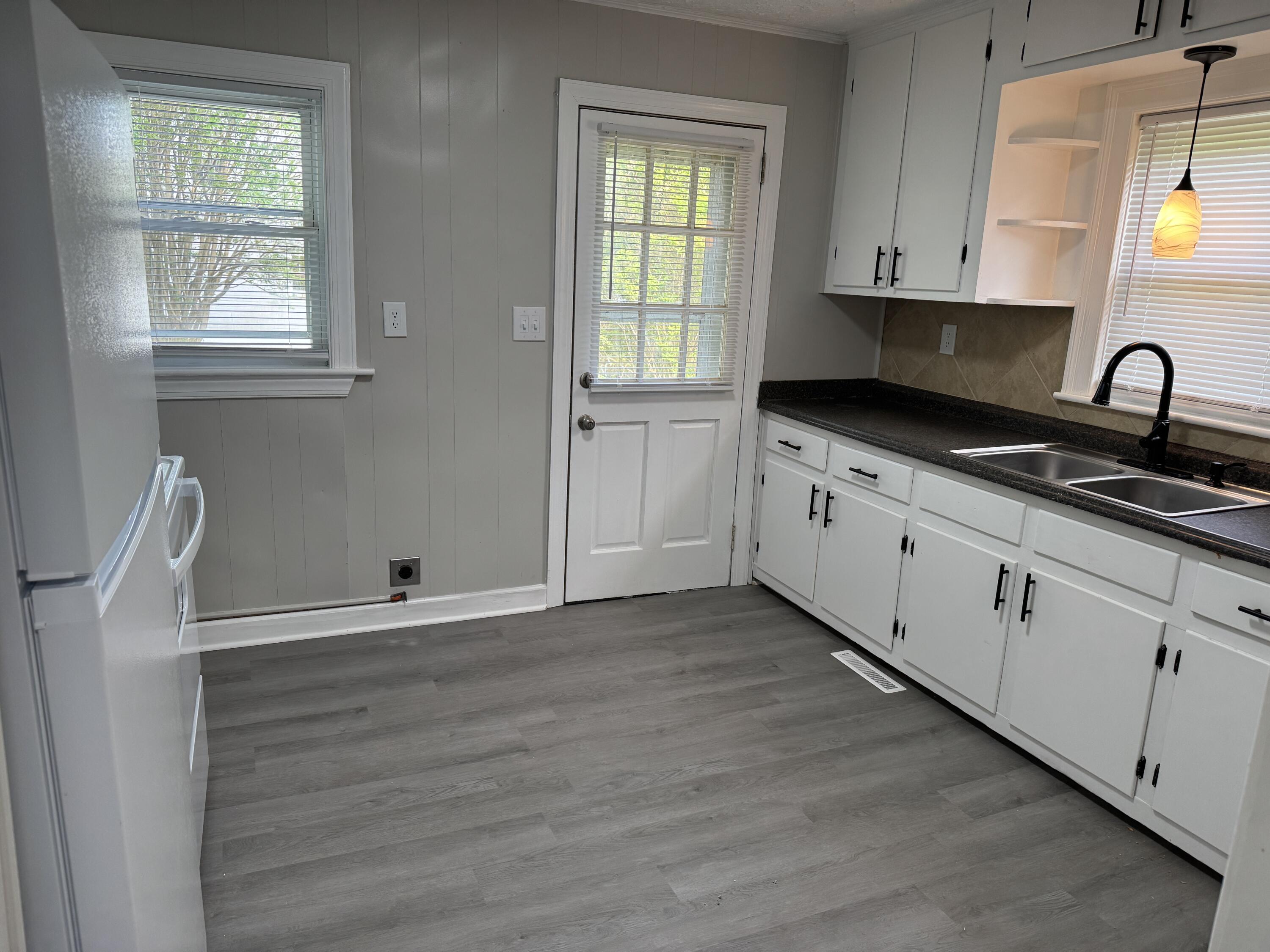 136 Nelson Avenue Danville, VA 24540 - Photo 6 of 7 a kitchen with granite countertop white cabinets and sink