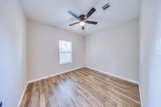 wooden floor in an empty room with a window