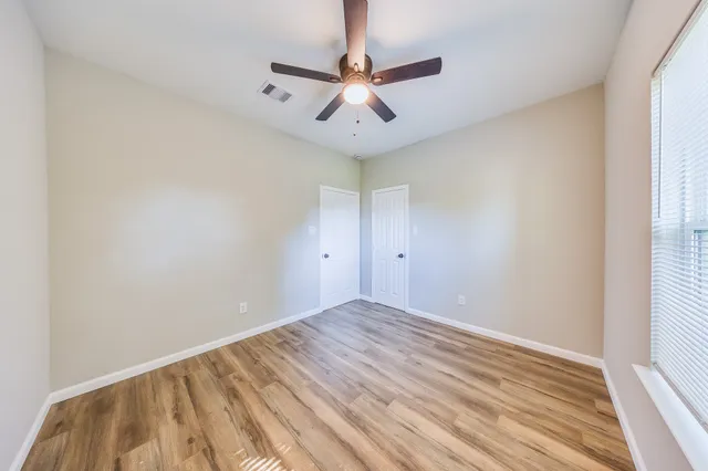 wooden floor in an empty room with a window