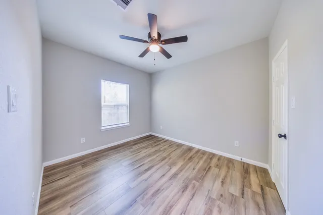 wooden floor in an empty room with a window