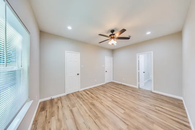 a view of a big room with wooden floor and a ceiling fan