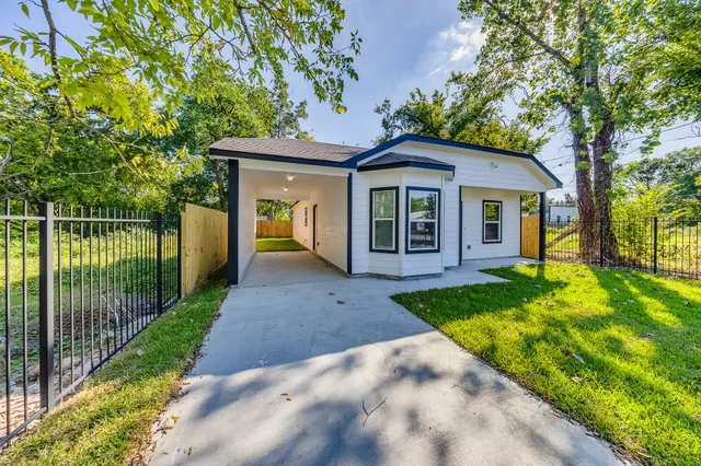 a view of a house with a yard and large tree