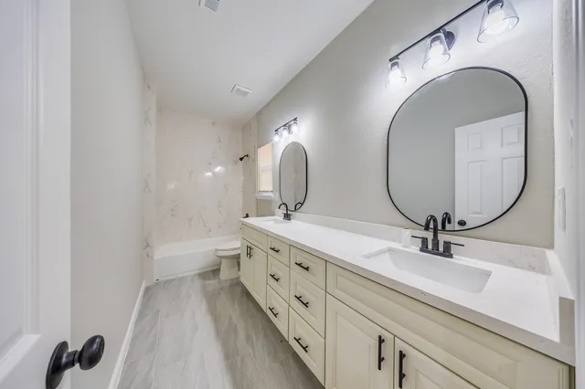 a bathroom with a double vanity sink and a mirror