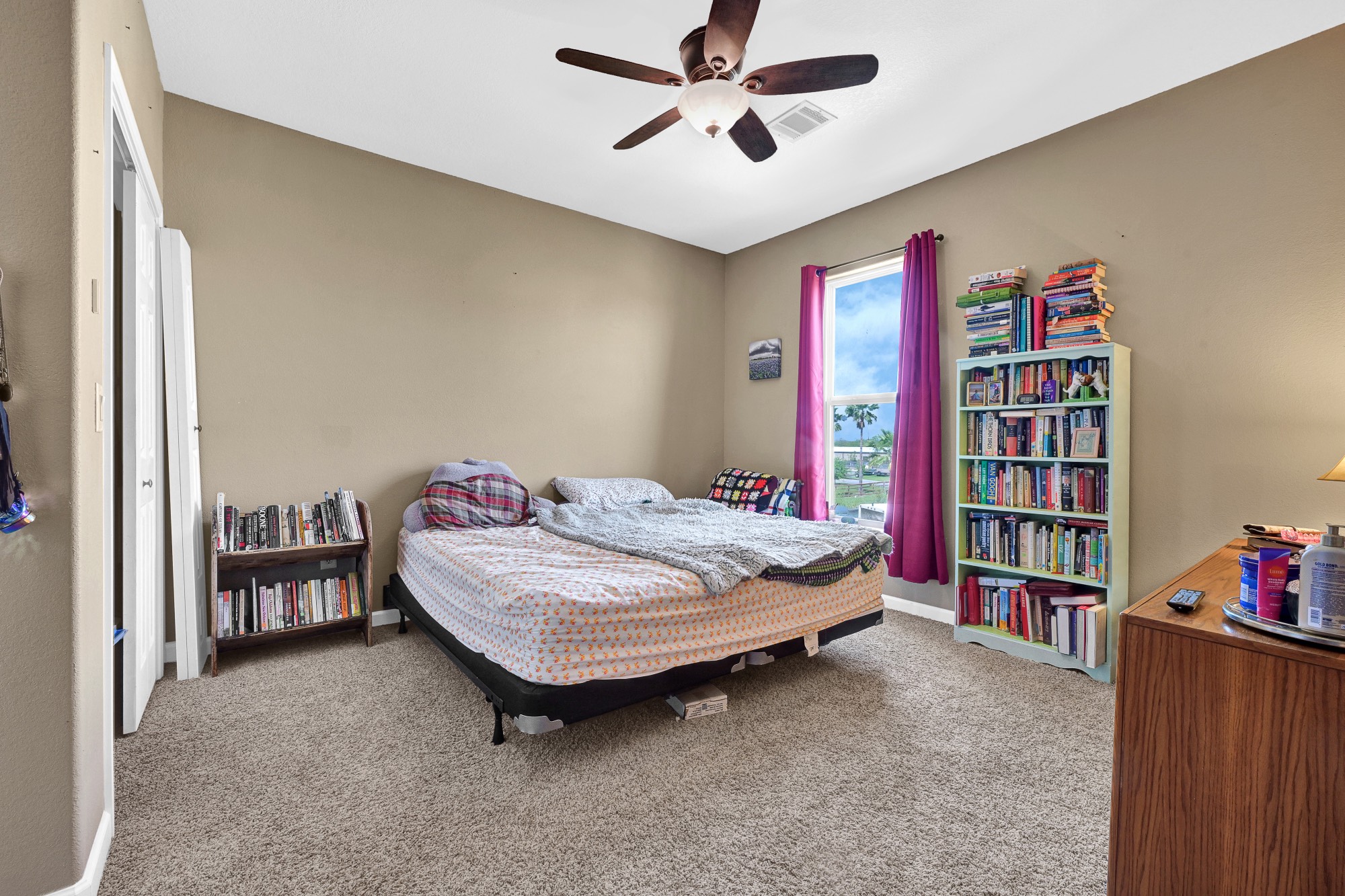 939 8th Street Dickinson, TX 77539 - Photo 26 of 31 This bedroom features a cozy carpeted floor, a ceiling fan, and ample natural light from a window