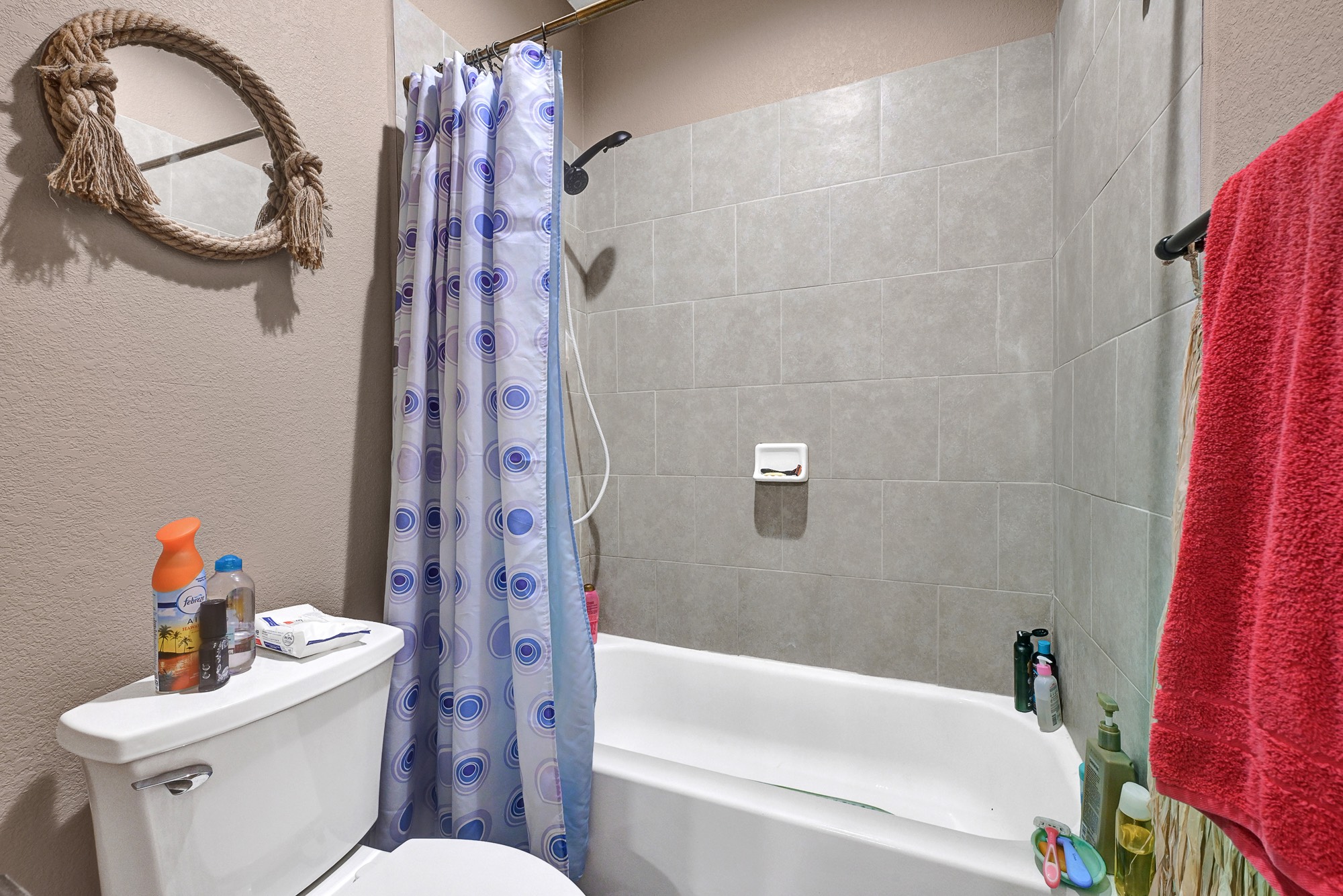 939 8th Street Dickinson, TX 77539 - Photo 27 of 31 This bathroom features a tiled shower area with a curtain and a bathtub. Simple and functional.
