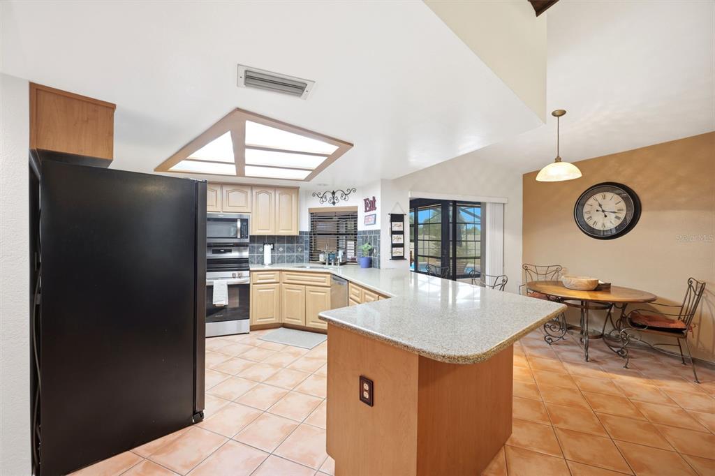 5227 Suwannee Road Weeki Wachee, FL 34607 - Photo 19 of 62 a kitchen with stainless steel appliances granite countertop a refrigerator and a stove top oven