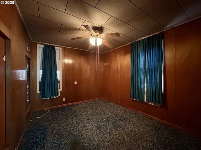 a view of a livingroom with a chandelier fan and windows
