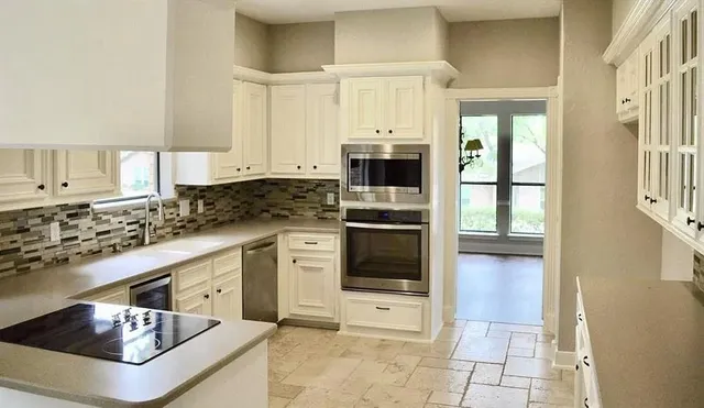 a kitchen with stainless steel appliances granite countertop a stove a sink and a refrigerator
