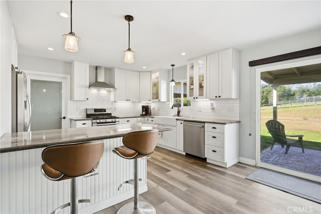 14010 Hilldale Road Valley Center, CA 92082 - Photo 6 of 28 a large kitchen with kitchen island granite countertop a large center island a stove a dining table and chairs