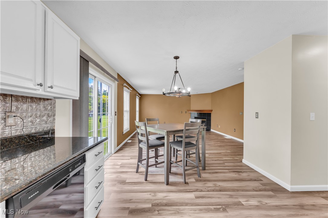 25861 Kennedy Ridge Road North Olmsted, OH 44070 - Photo 11 of 24 Dining area featuring baseboards, light wood-style floors, and a chandelier