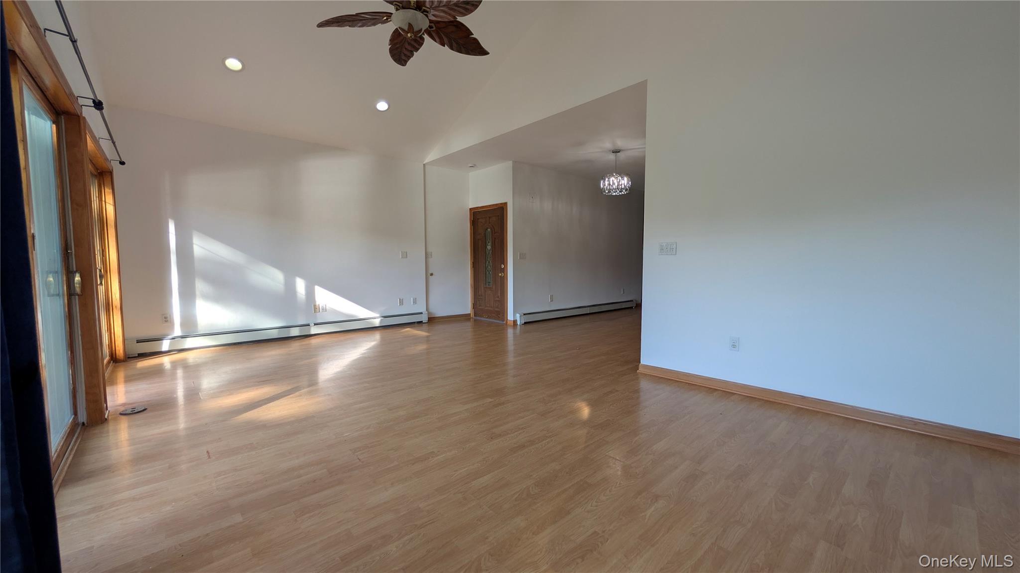 169 Shear Hill Road Mahopac, NY 10541 - Photo 9 of 31 Empty room featuring light wood-style flooring, baseboard heating, recessed lighting, a ceiling fan, and a chandelier
