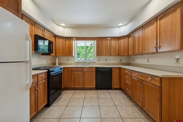 a kitchen with a sink a stove top oven a refrigerator and window