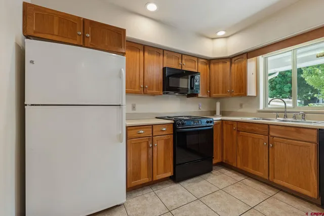 a kitchen with a refrigerator stove top oven a sink and dishwasher