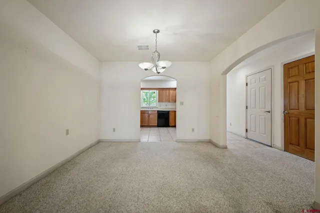 an empty room with chandelier and windows