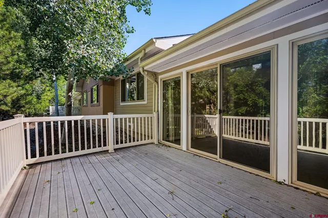 a view of deck with wooden floor and fence next to a yard