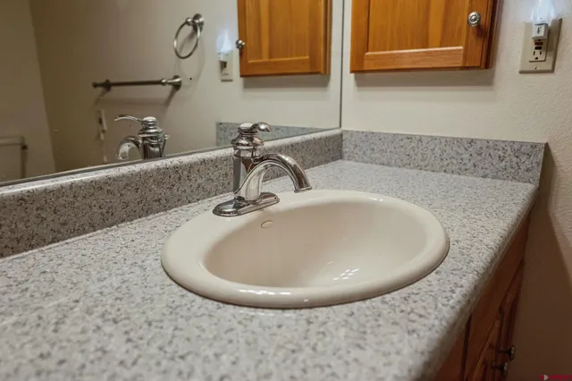 a bathroom with a granite countertop sink and a mirror