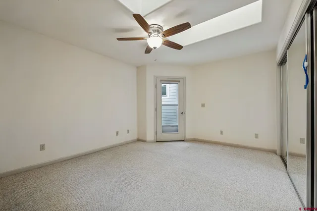 an empty room with ceiling fan and window