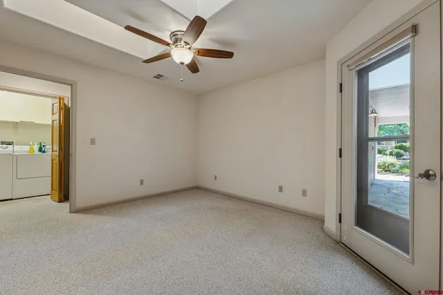 an empty room with a ceiling fan and window