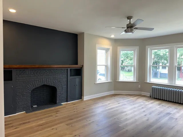 wooden floor fireplace and windows in an empty room