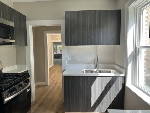 a room with a sink a window and stainless steel appliances